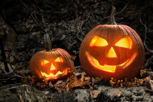 Two jack-o-lanterns in a woodland setting